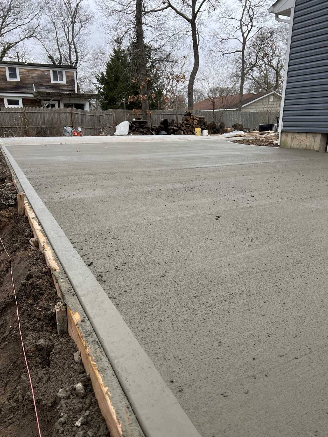 Formed and poured concrete slab along the side of a house