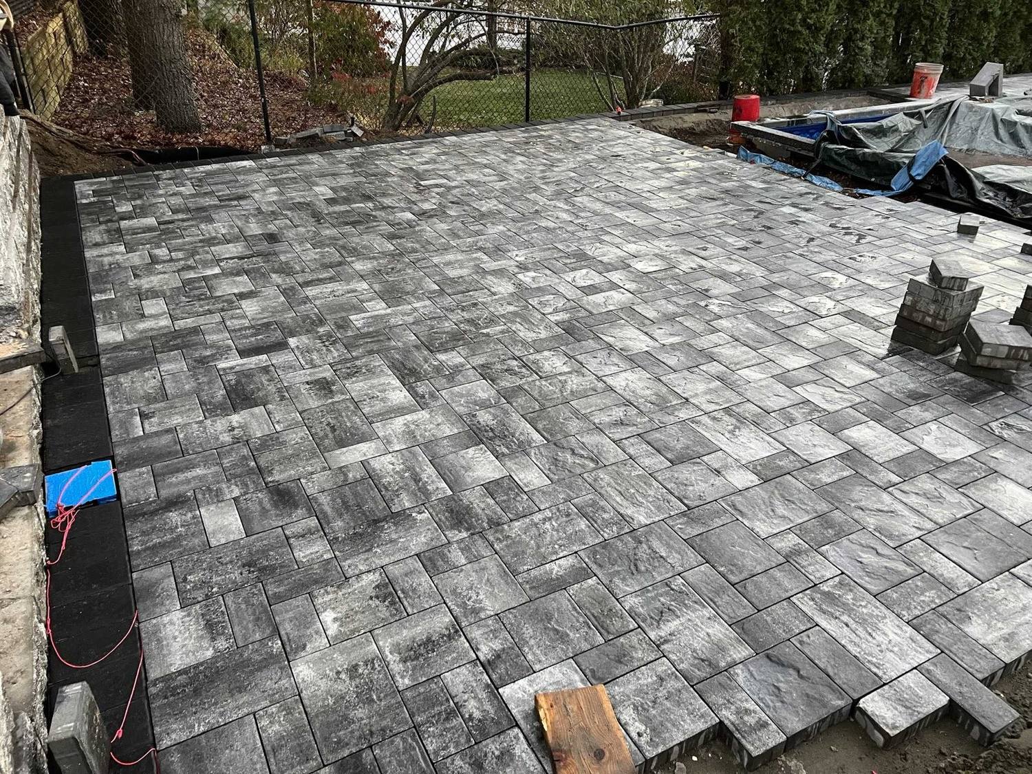 Large-format paver patio being laid in a running-bond pattern