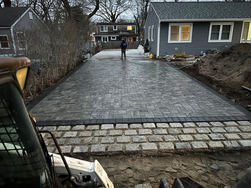 Granite cobble driveway to the front door by JDG Concrete & Construction