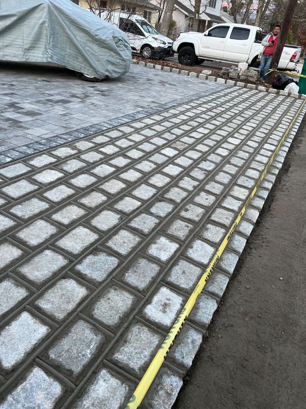 Cobble driveway, sand swept in by JDG Concrete & Construction