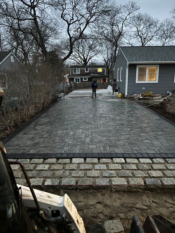 Cobble driveway at dusk by JDG Concrete & Construction