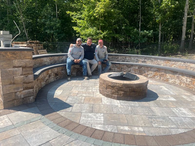 The crew on a finished fire pit and seating wall by JDG Concrete & Construction