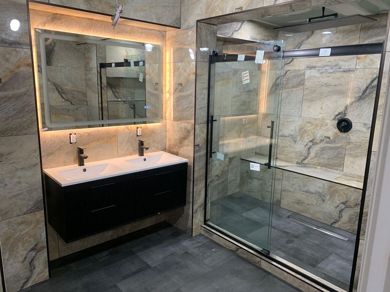 Backlit LED mirror over the vanity by JDG Concrete & Construction