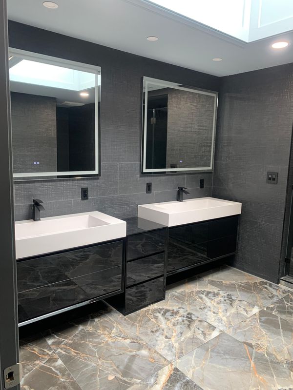 Floating double vanity under the skylight by JDG Concrete & Construction