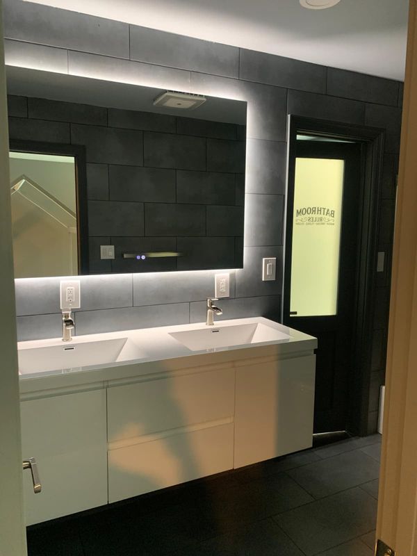 Floating vanity with wall-mounted faucets by JDG Concrete & Construction