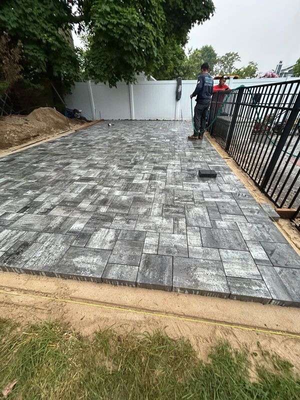 Paver patio with charcoal border at the side gate by JDG Concrete & Construction