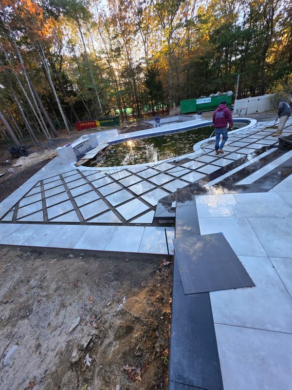 Pool deck pavers going down, diagonal bands laid out by JDG Concrete & Construction