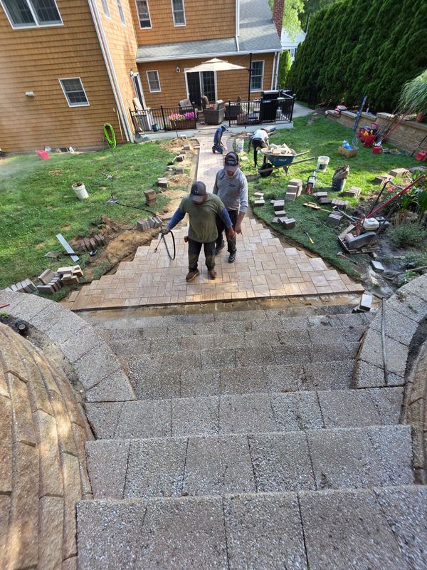 Tan paver walkway with stone steps by JDG Concrete & Construction