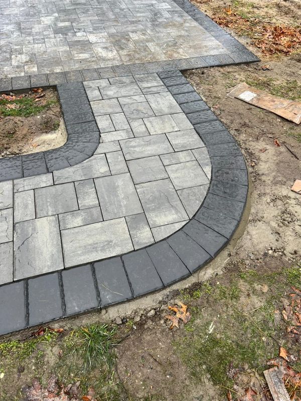 Curved walkway with a charcoal soldier course by JDG Concrete & Construction