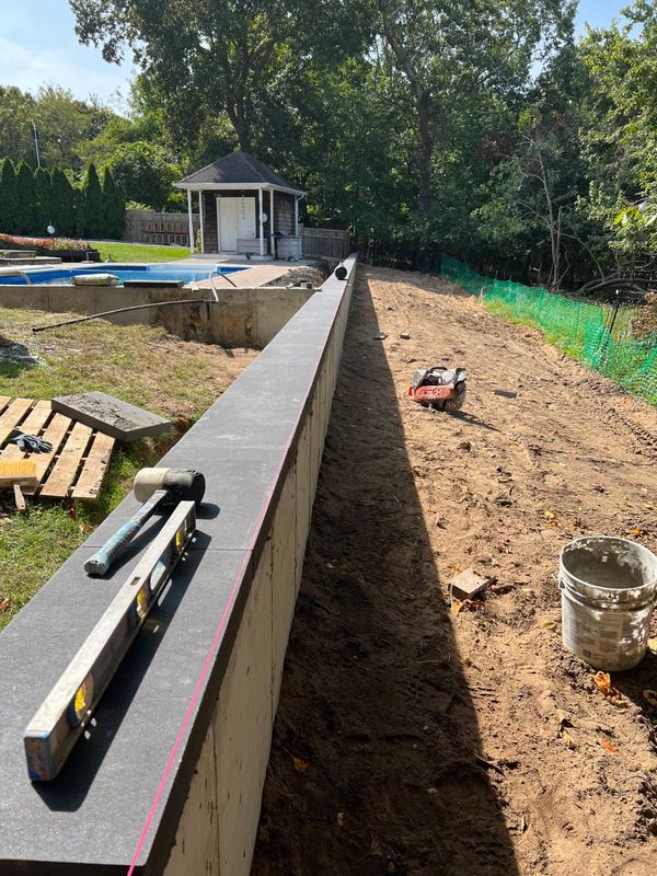 Wall cap being set and leveled by JDG Concrete & Construction