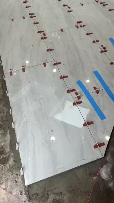 Large-format floor tile on leveling clips by JDG Concrete & Construction